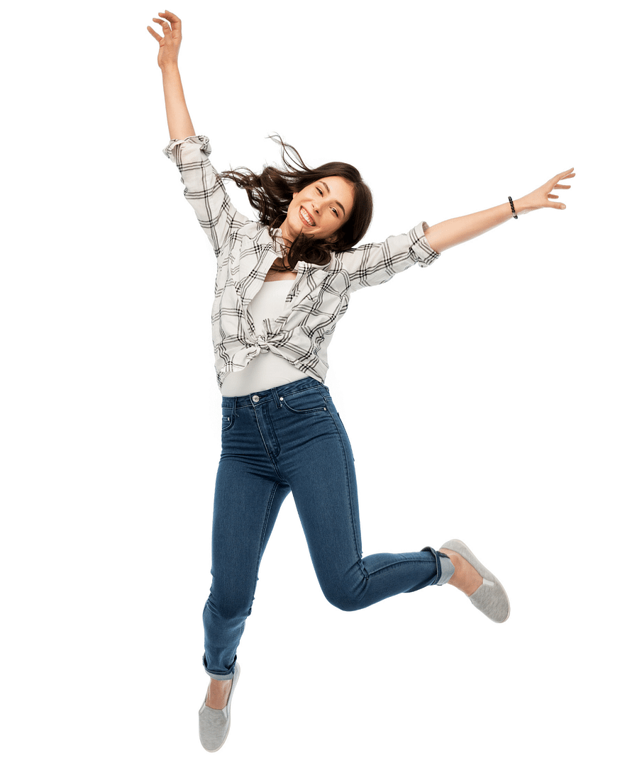 Woman in blue jeans jumping in the air happily with a big smile