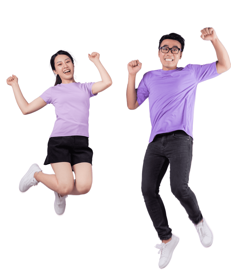 Two people wearing purple shirts jumping in the air smiling